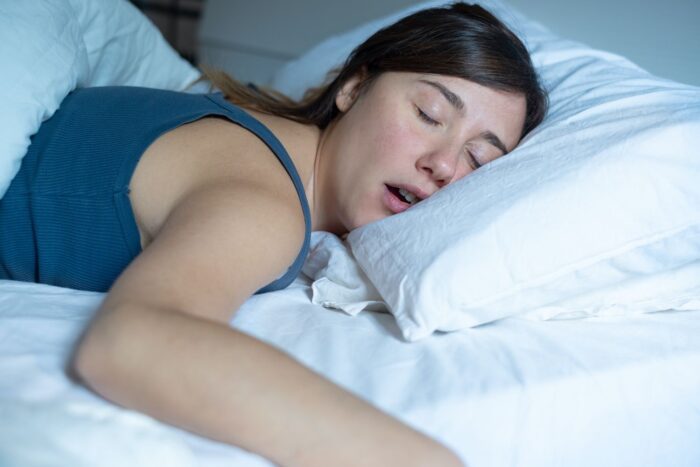 Portrait of one tired woman snoring in bed sleep apnea restorative dentistry dentist in Tulsa Oklahoma